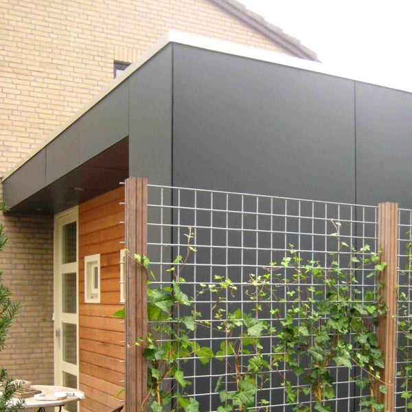 Aanbouw met donkergrijs HPL platen 6 mm gevel en houten bekleding, daarachter een klimrek