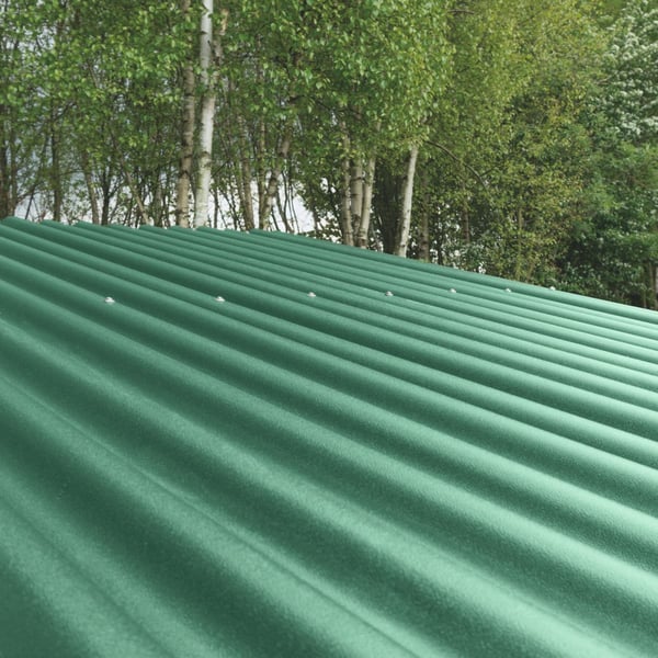 Groene profielplaten ReWell 94/34 op een dak met bomen op de achtergrond