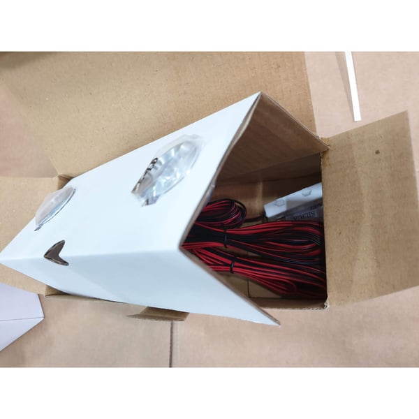 Twee LED verlichting extra spots, blank aluminium, met kabels in de geopende productverpakking