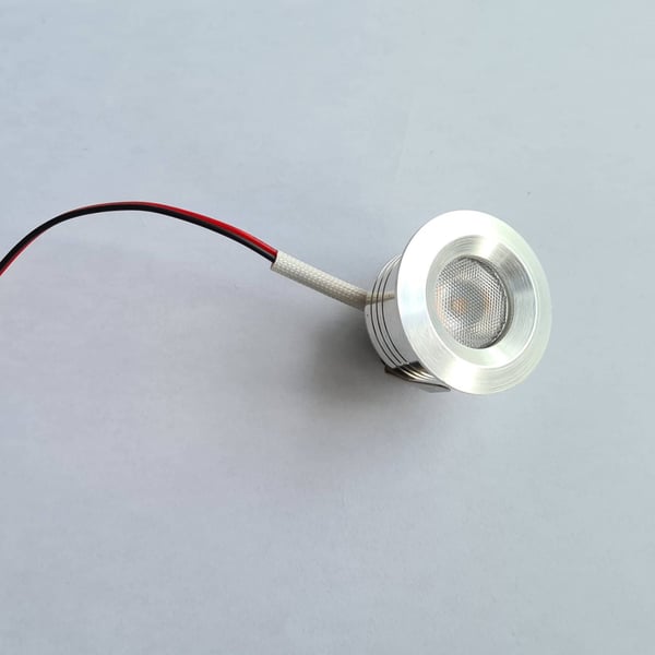Detail van een enkele ronde LED lamp van blank aluminium, uitgeschakeld