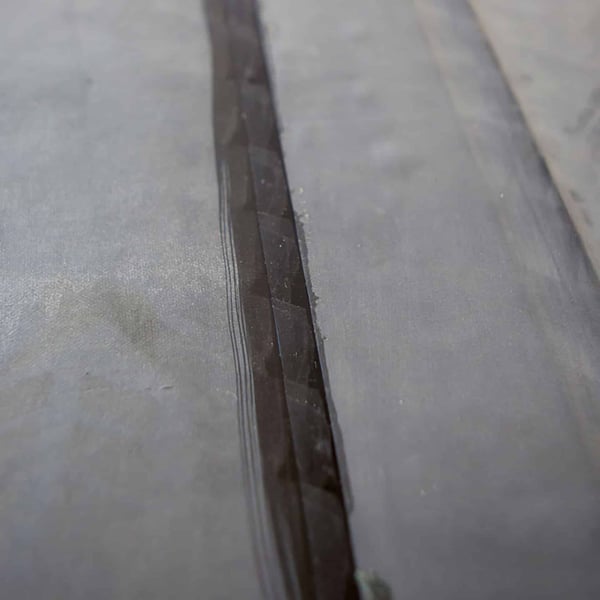 Detail van een verlijmde naad met zwart EPDM naadband op een dakbedekking