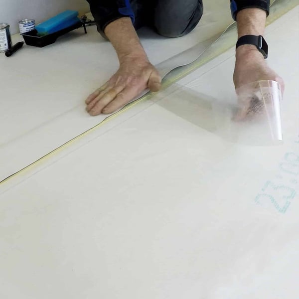 DACHPROTECT Naadband EPDM 0,75 mm wit wordt met de hand op dakbaan aangedrukt