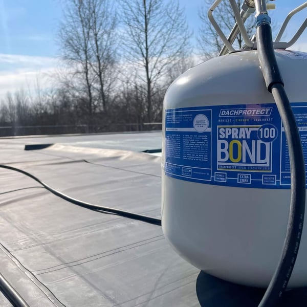 DACHPROTECT Spraybond 100 oppervlakte lijmbus, crèmekleurig met blauw etiket, op dakbedekking