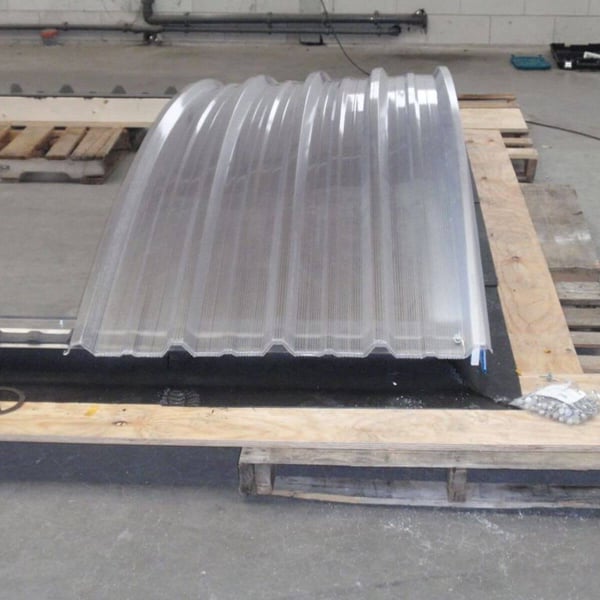 Gebogen lichtplaat van aluminium, blank, met profielstructuur op houten pallet
