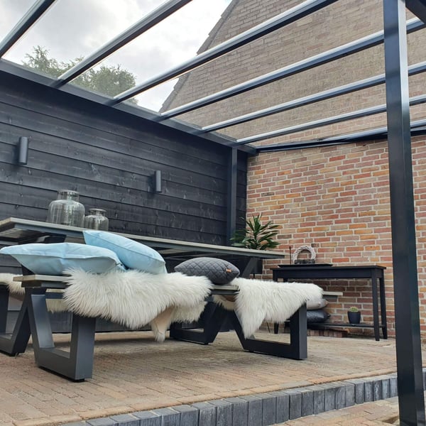 Zitgedeelte onder een terrasoverkapping met heldere polycarbonaat lichtplaten