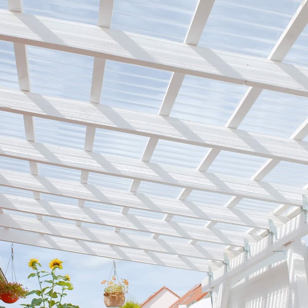 Gelegde heldere polycarbonaat golfplaten 76/18 als terrasoverkapping met bloemen en zonnebloemen