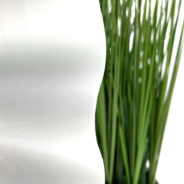 Detail van de opaal witte polycarbonaat golfplaat met een wazige groene plant op de achtergrond