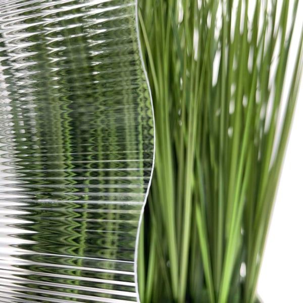 Polycarbonaat golfplaat 1,40 mm helder, detail van de golfstructuur met vervormde achtergrond