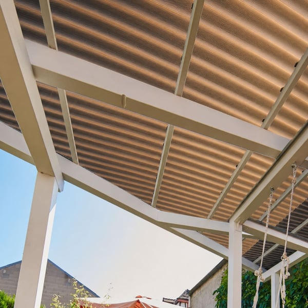 Scobalit polycarbonaat golfplaten 76/18, 2,60 mm brons, gemonteerd als dak van een pergola