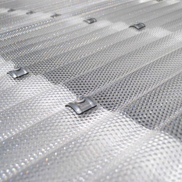 Close-up van de bevestiging van een heldere polycarbonaat golfplaat 76/18 met schroef en kalot
