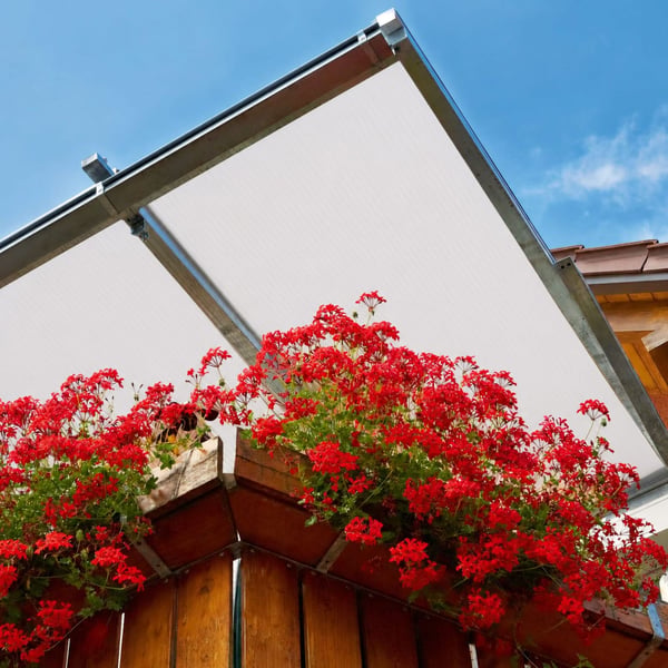 Metalen terrasoverkapping met opaal witte Scobalit polycarbonaat lichtplaten en bloemen