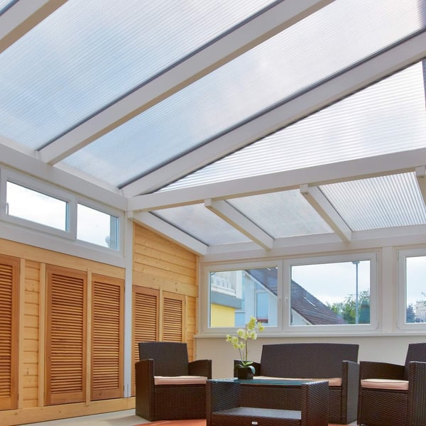 Helder polycarbonaat lichtplaat 25 mm als dakbedekking van een serre, interieur met meubels