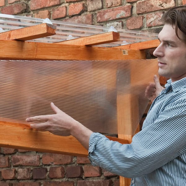 Man monteert een polycarbonaat dubbelwandige plaat 6 mm, helder, aan een houten constructie