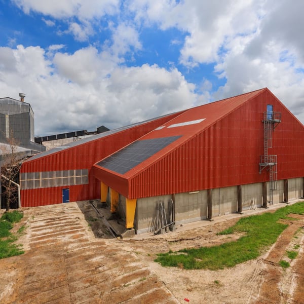 Groot industrieel gebouw met terracotta golfplaten dak en gevel