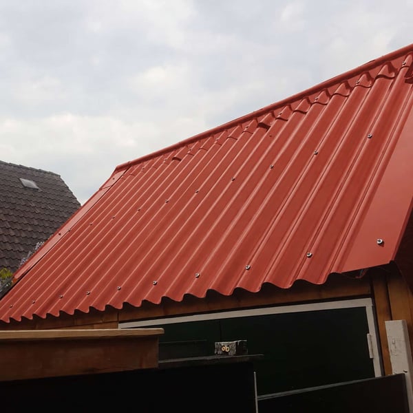 Terracotta golfplaten dak met schroeven op een tuinhuis of afdak