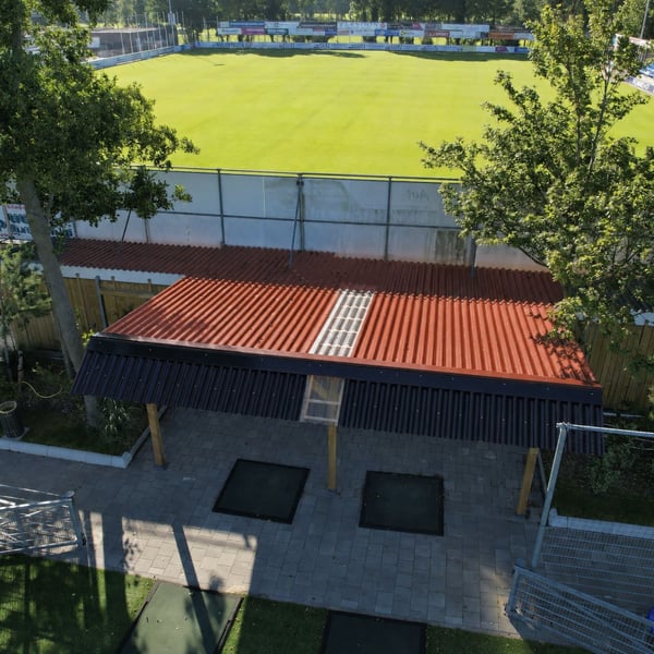 Bovenaanzicht van overkapping met terracotta golfplaten dak en lichtplaat