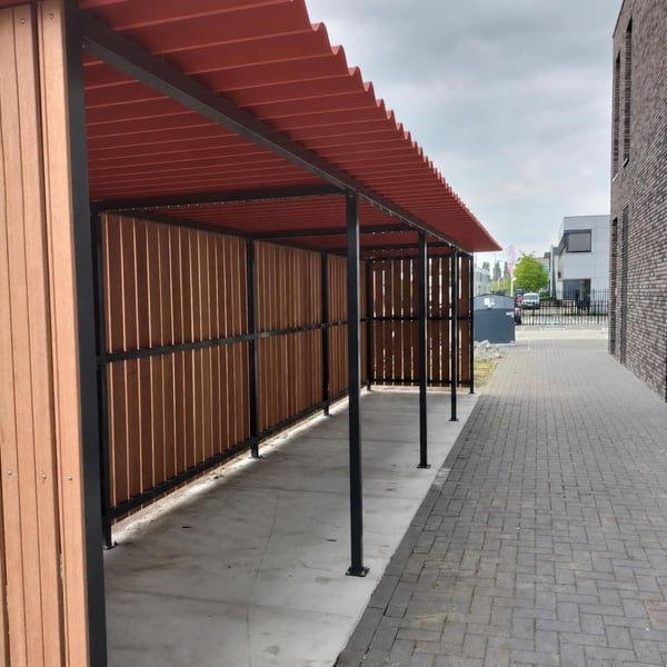 Lange carport met terracotta golfplaten dak en houten zijwanden