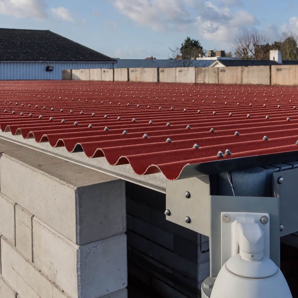 Detail van terracotta golfplaten dak met bevestigingsschroeven op een constructie