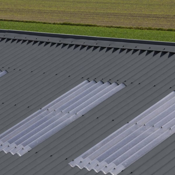 Detail van donkergrijze golfplaten met lichtplaten op een dak, verlegd