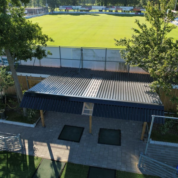 Bovenaanzicht van een carport met donkergrijze golfplaten en lichtplaten, verlegd