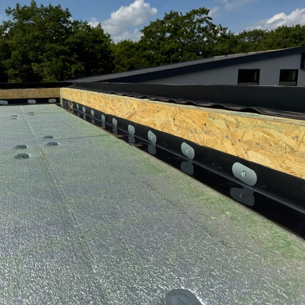 Randfixatiestrip EPDM zwart gemonteerd op houten onderconstructie van een plat dak