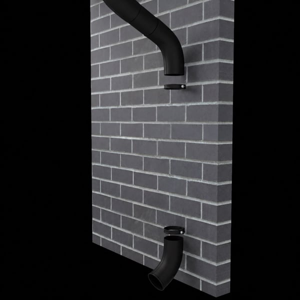 Twee gitzwarte stalen afvoerbochten (RAL 9005) gemonteerd op een grijze bakstenen muur