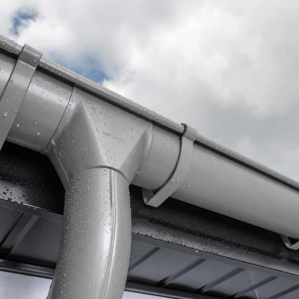 Grijs aluminiumkleurige (RAL9007) fallrohrbocht van staal met waterdruppels na regenval