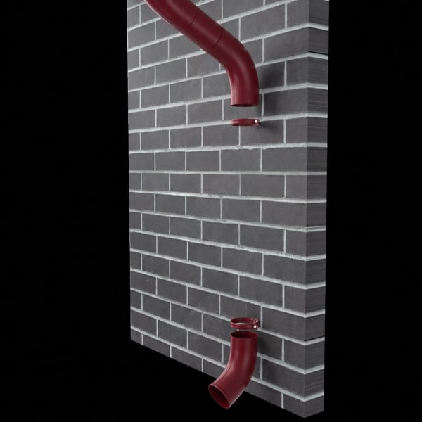 Twee kersrode stalen valpijpbochten gemonteerd op een donkergrijze bakstenen muur