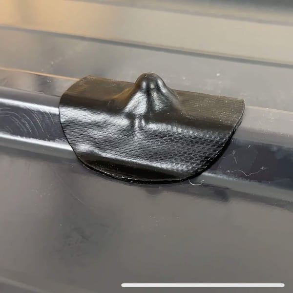 Zwarte EPDM schroef reparatiepleister op een donkere profielplaat