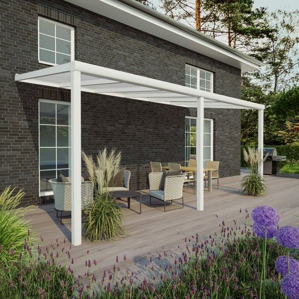 Terrasoverkapping RAL 9016 van Sunrooms, 16 mm, aan een huis met donkere bakstenen muur