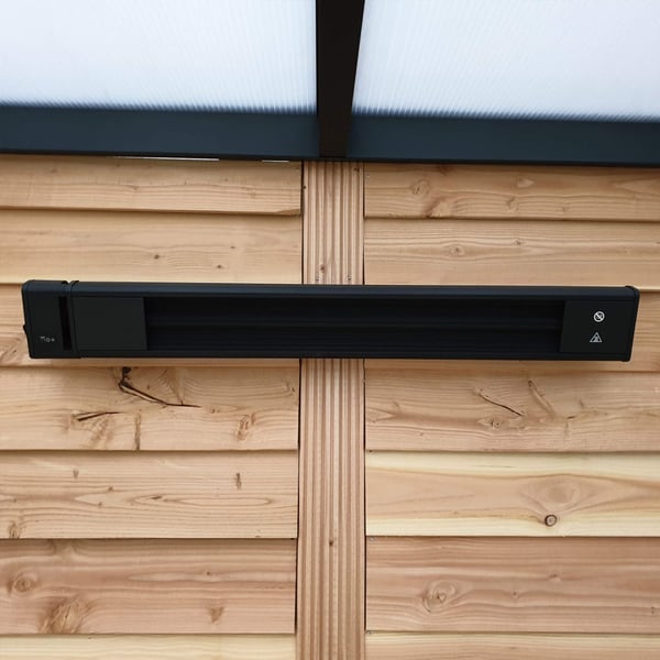 Verwarming aluminium zwart, gemonteerd aan houten wand, direct vooraanzicht