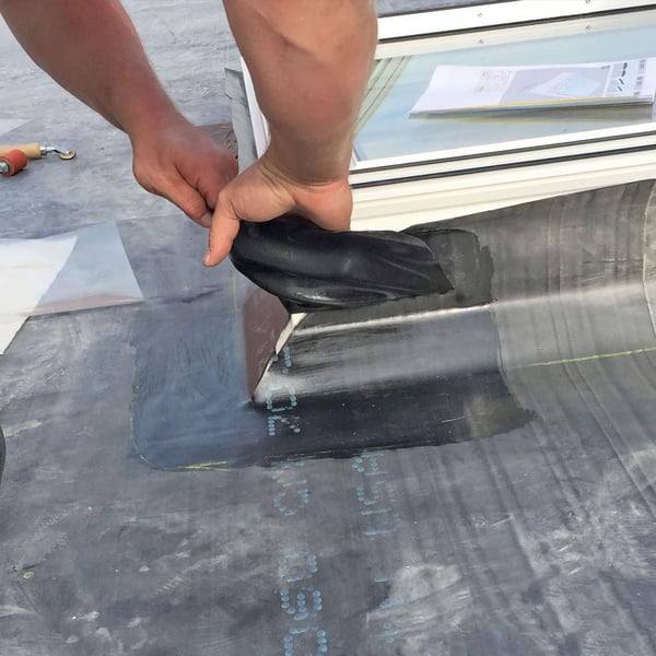 Montage van het zwarte DACHPROTECT vorm- en afdekband van EPDM bij een dakraam