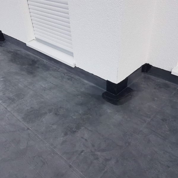 Plaatsing van het zwarte DACHPROTECT vorm- en afdekband van EPDM op een dakhoek