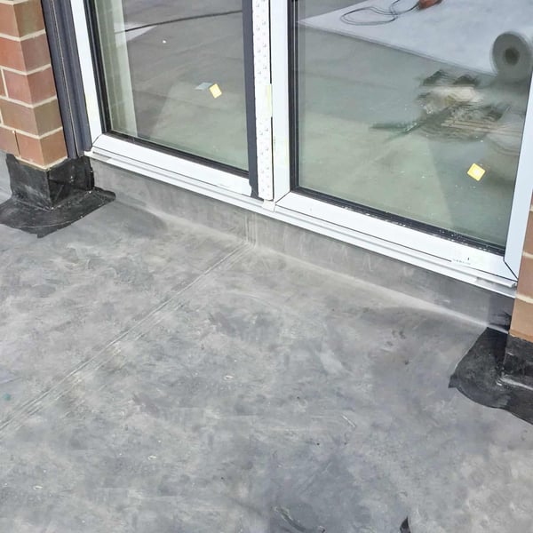 Plaatsing van het zwarte DACHPROTECT vorm- en afdekband van EPDM bij een terrasdeur