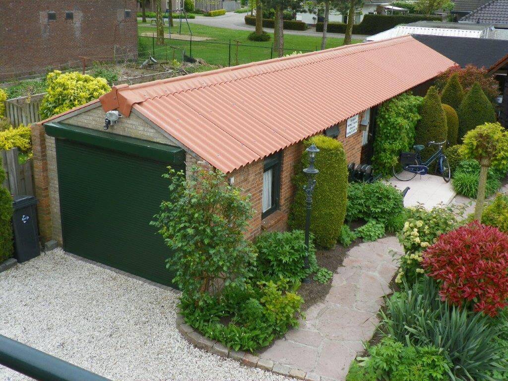 Een carport met gemonteerde vezelcementplaten in roodbruin.
