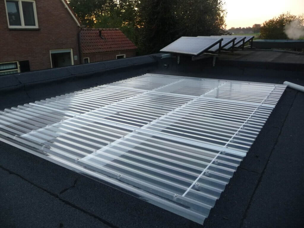 Uitsnede van een plat dak met doorzichtige golfplaten.