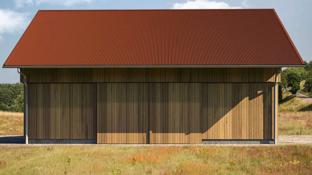 Schuurachtig gebouw met gevel van verticaal gemonteerde houten profielen en roodbruin dak van smal gegolfde profielplaten, gelegen in een open weidelandschap onder blauwe lucht.