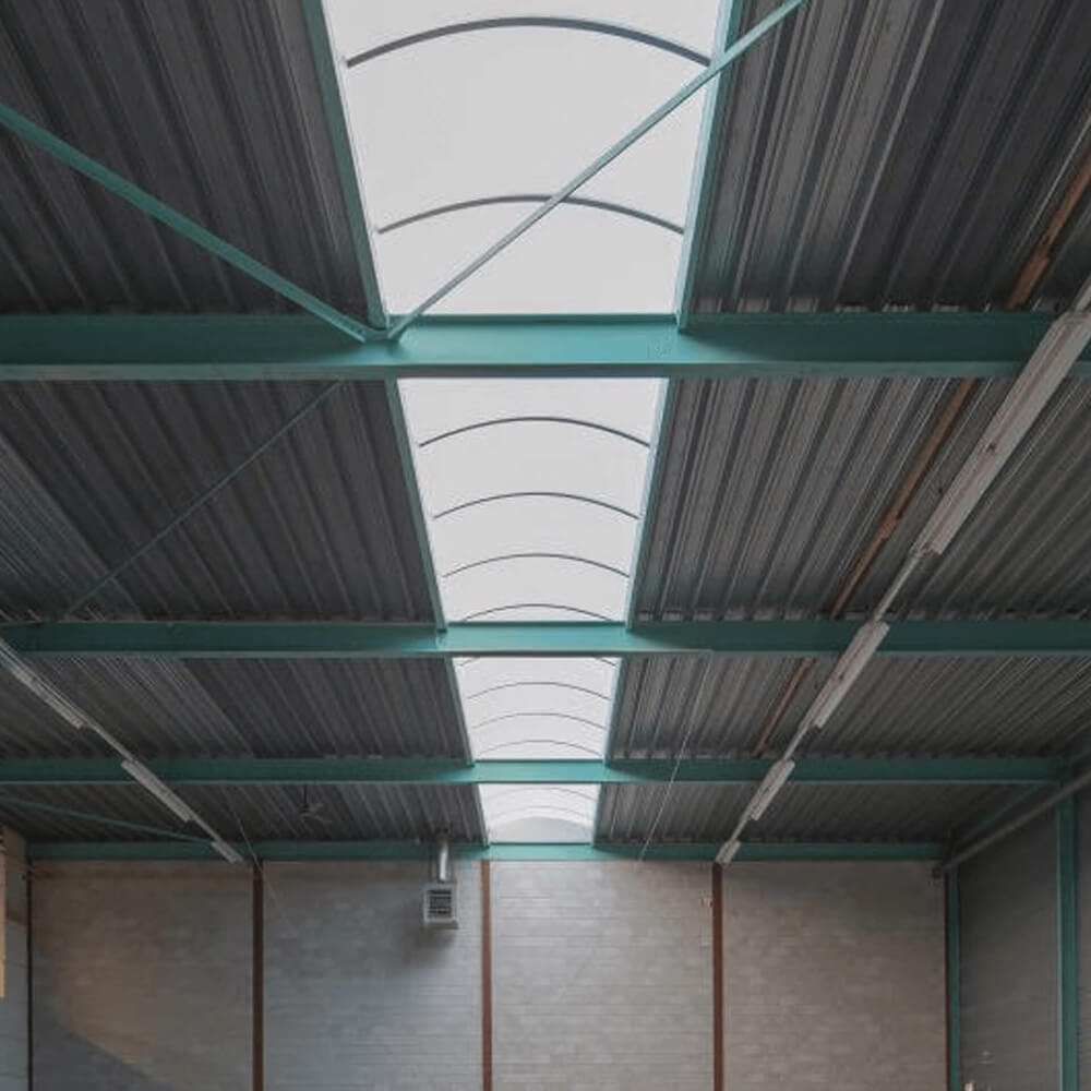 Binnenzicht van een hal met professioneel geïnstalleerde gebogen lichtstraten die een heldere sfeer scheppen