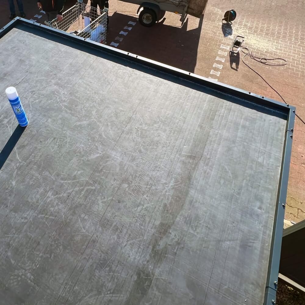 Hoogwaardige EPDM dakfolie aangebracht op een plat dak EPDM dakfolie professioneel gelegd op een plat dak, werkmateriaal en gereedschap zichtbaar op de achtergrond