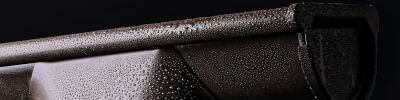 Close-up van een dakgoot met waterdruppels, waaruit de robuustheid en efficiëntie in natte omstandigheden blijkt