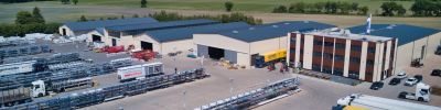 Luchtfoto van een logistiek centrum met opgeslagen bouwmaterialen en bestelwagens